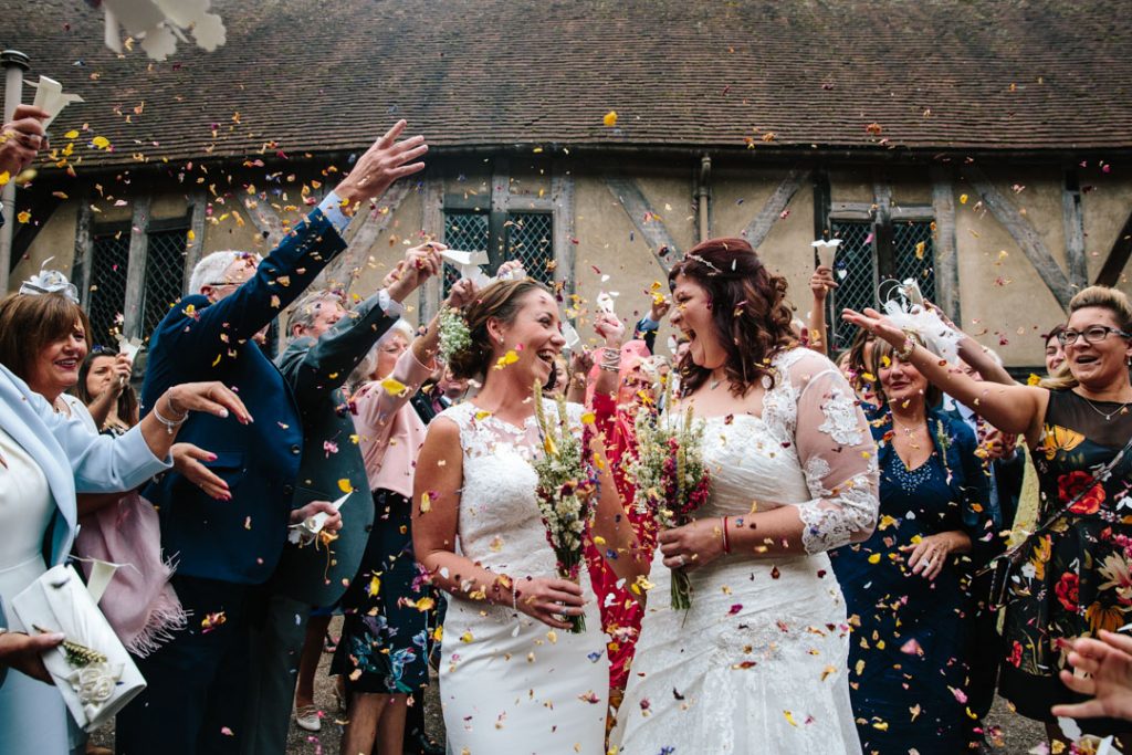 Two brides, confetti being thrown, Lord Leycester Hospital