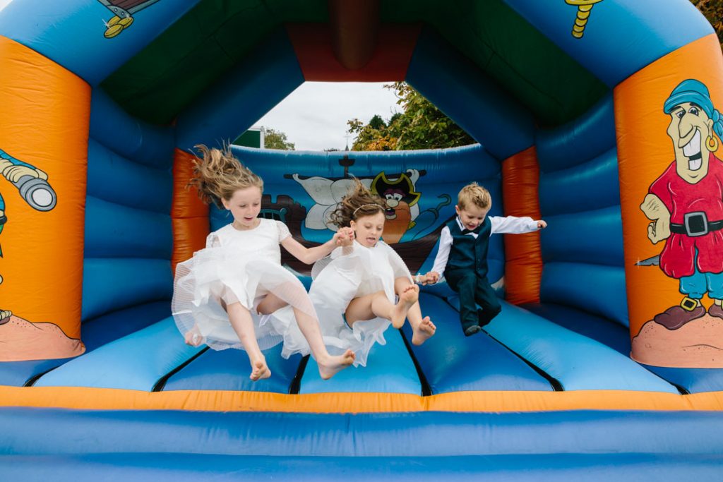 Children jumping on a bouncy castle at a wedding