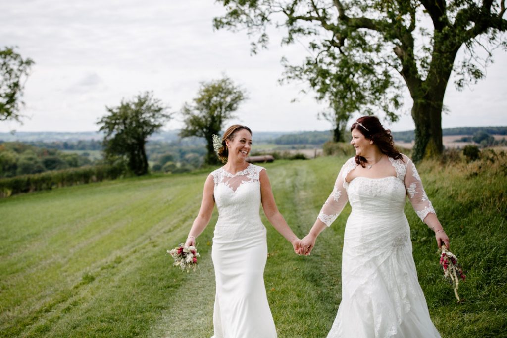 Two brides walking across a field