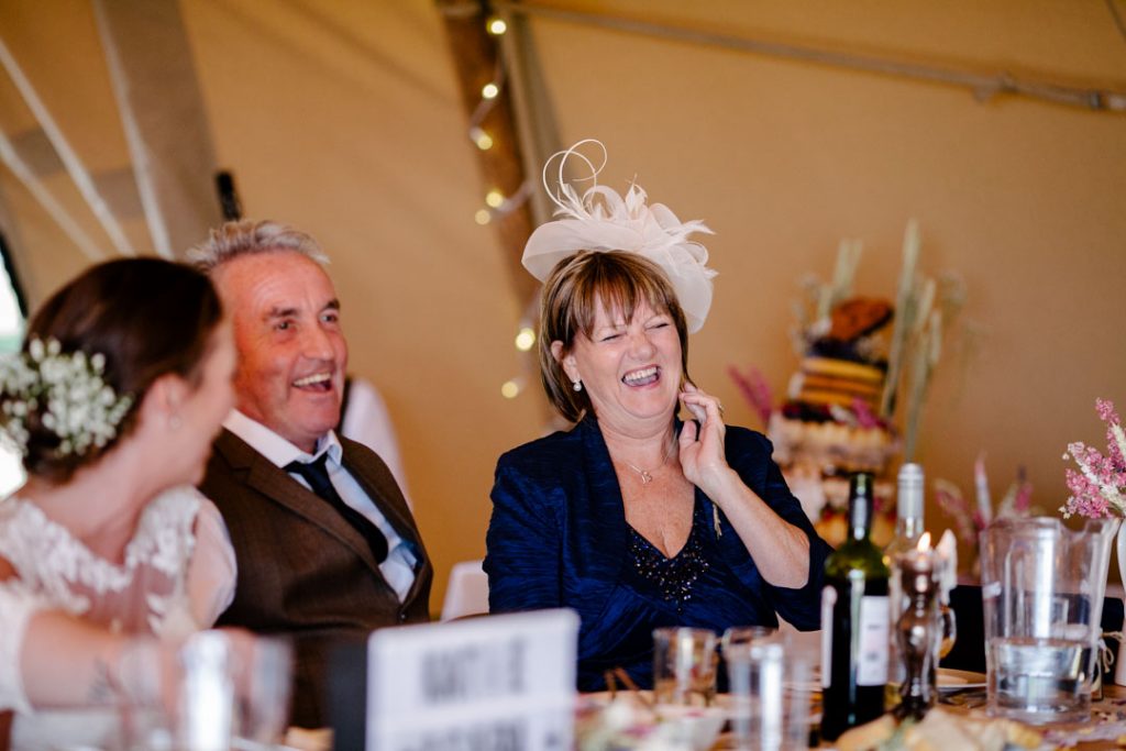 Mother of the bride laughing during speeches, tipi wedding