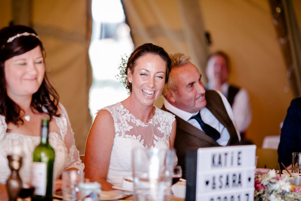 Bride laughing during speeches, tipi wedding