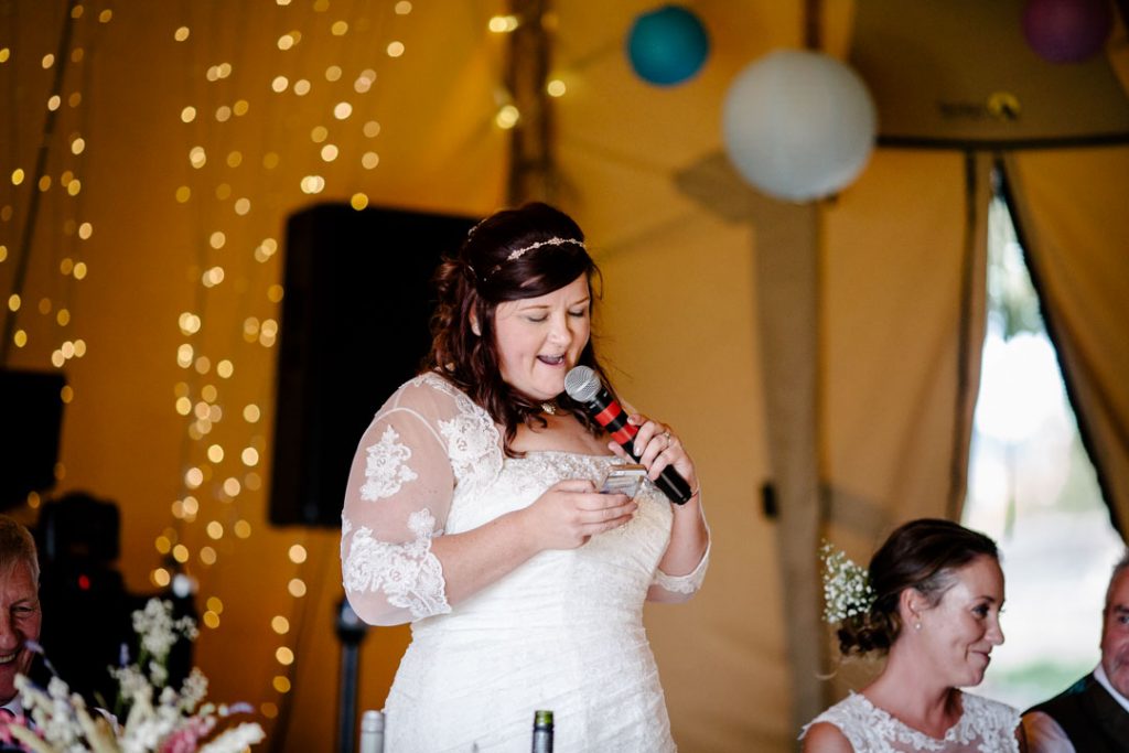 Bride giving a speech during wedding breakfast in a tipi