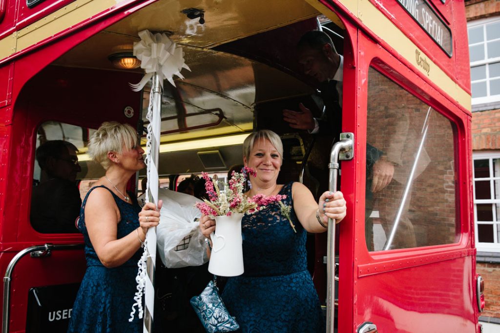 Bridesmaids on red double decker bus