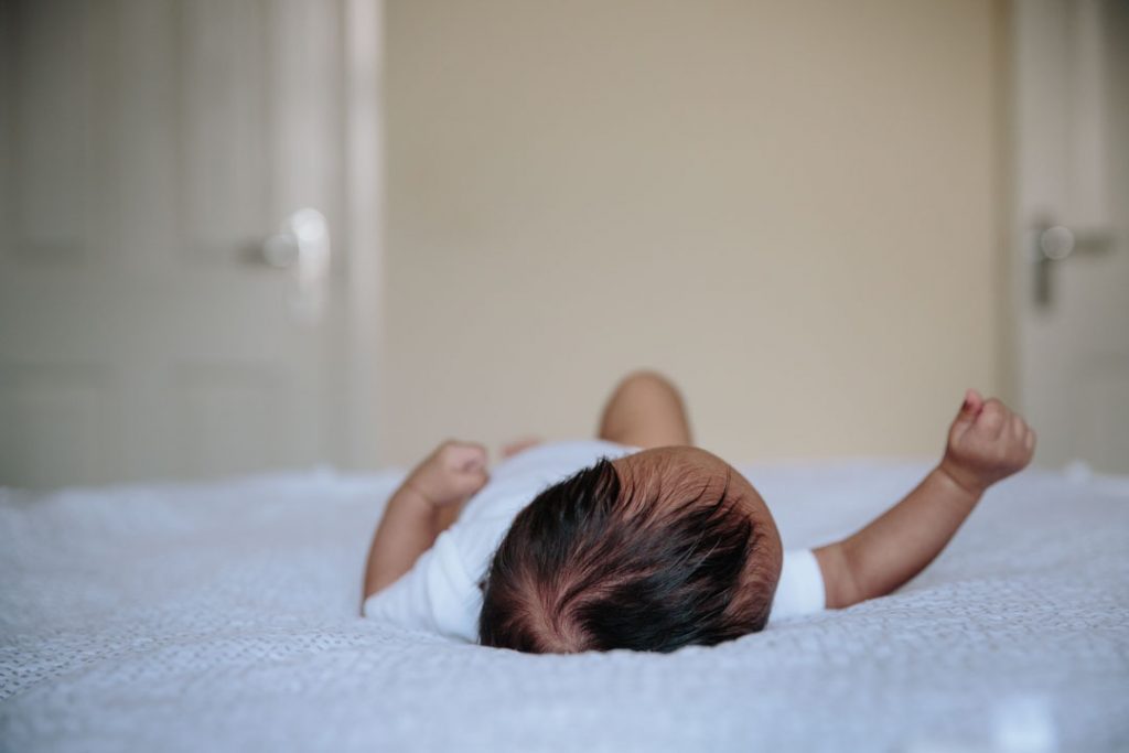 Image of baby's head as he lies on the bed