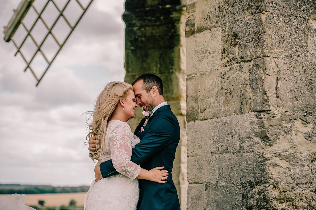 bride and groom standing close for couple shots
, hugging under chesterton Windmill in Leamington