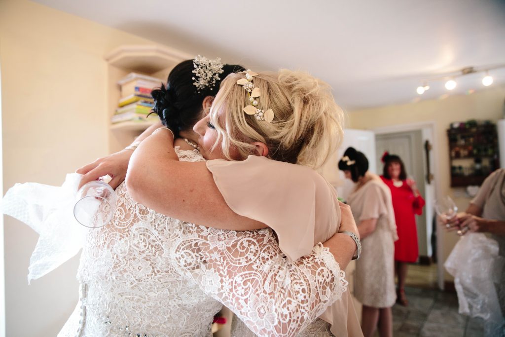 bridesmaid hugging bride after opening a gift