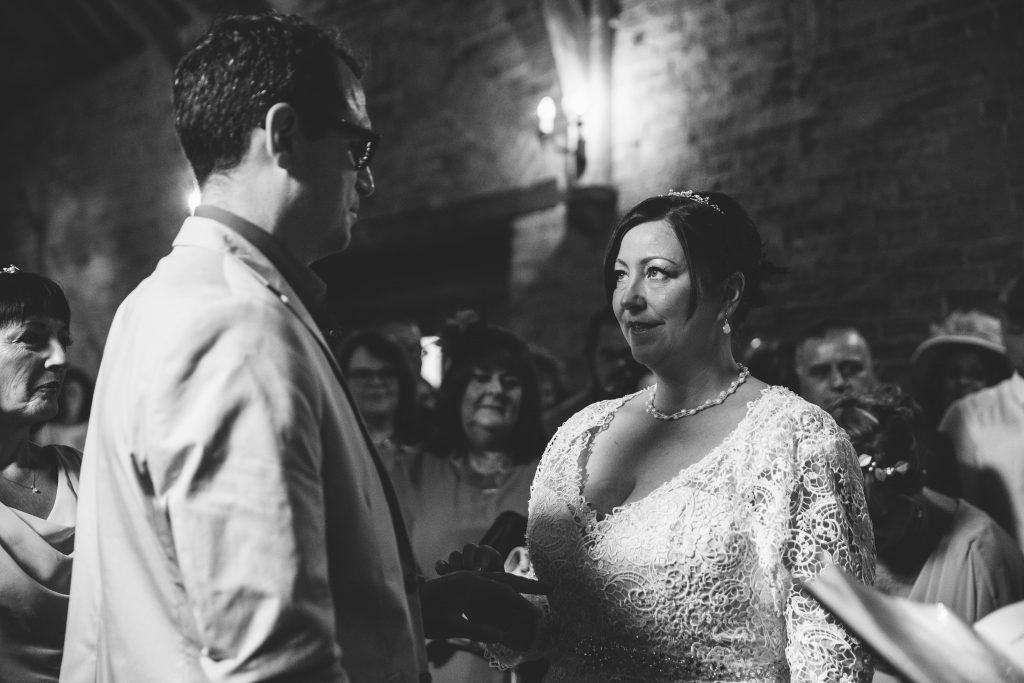 Bride & Groom, exchanging wedding rings during wedding ceremony at Dovecote Barn