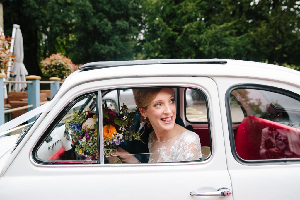 Bride arriving at her wedding at the Saxon Mill in her Fiat 500