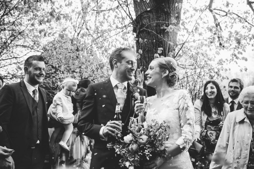 Black & white image of confetti, bride and groom, Saxon Mill wedding