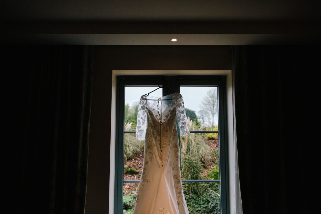 Wedding dress hanging up at the window at The Warwickshire hotel