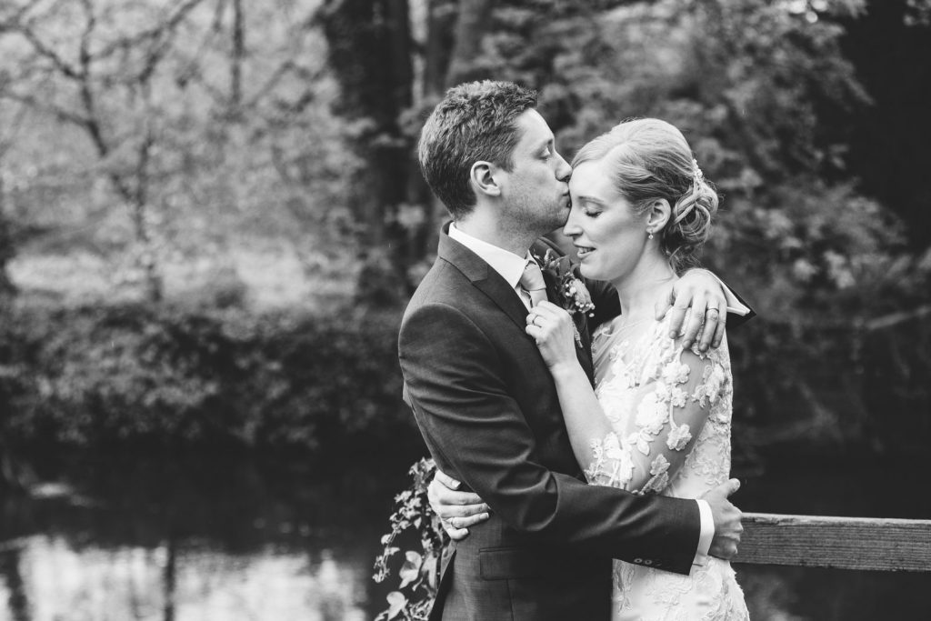 BRide & Groom standing by the riverside at The Saxon Mill, Warwickshire
