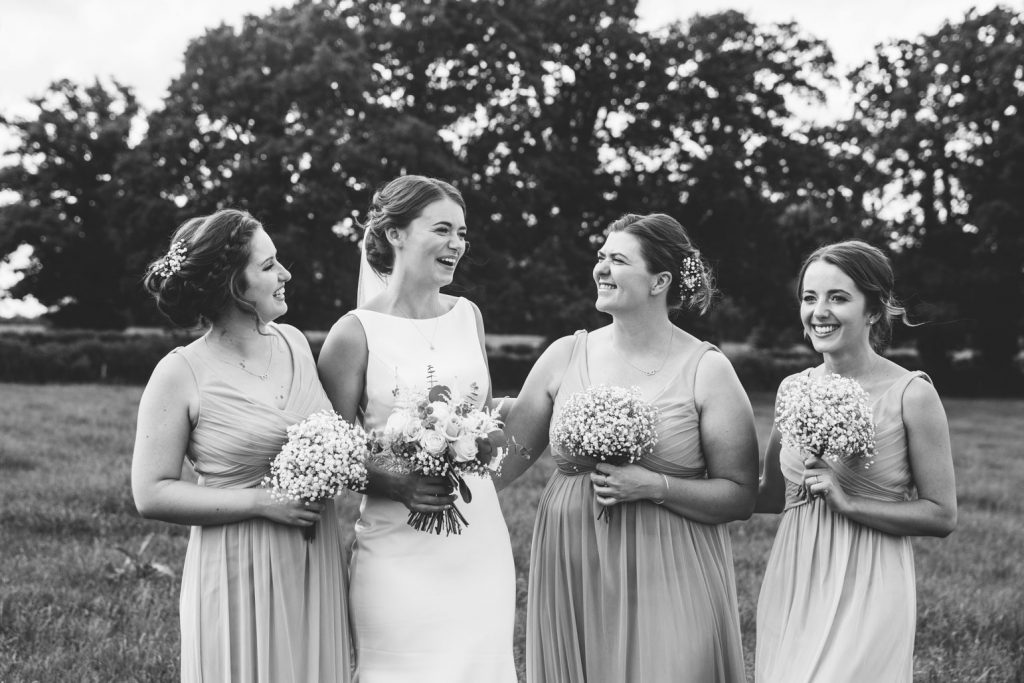 Bride laughing with her bridesmaids