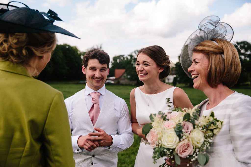 Bride, groom and mother of the bride laughing