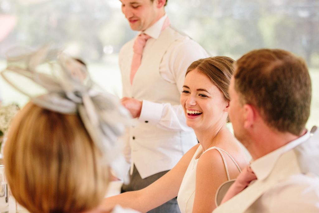 Bride laughing during Groom's wedding speech