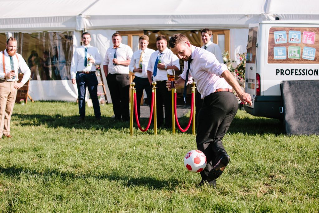 Man playing football at a marquee wedding