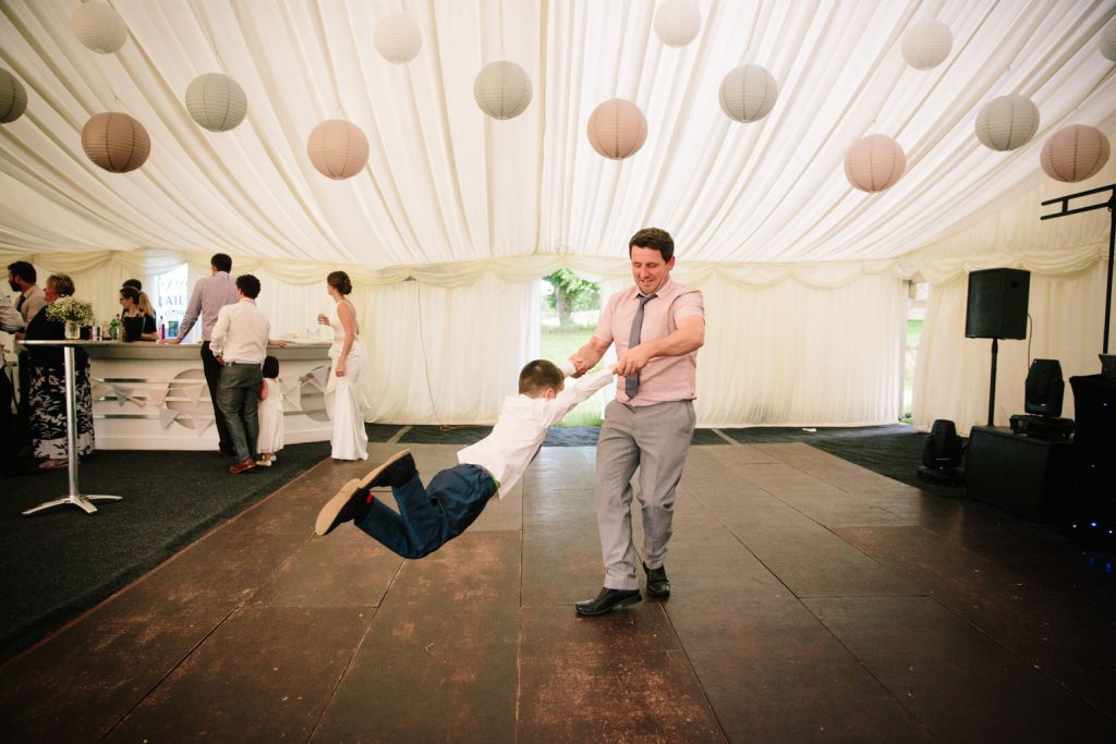 Man swinging child round on the dance floor