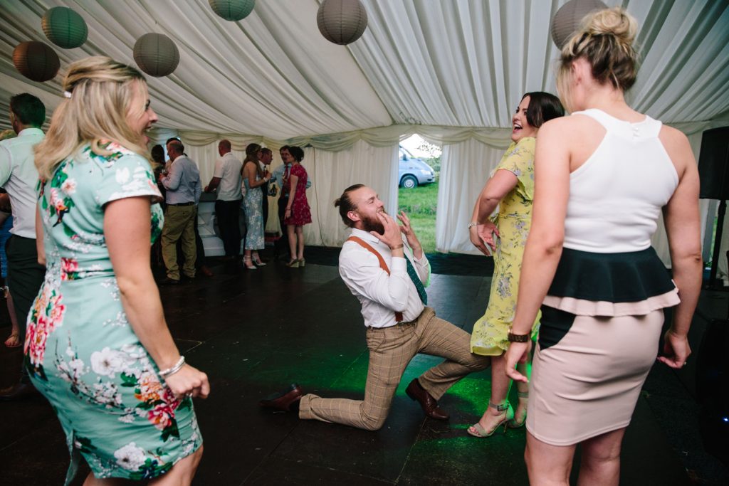 Wedding guests dancing and laughing at marquee wedding