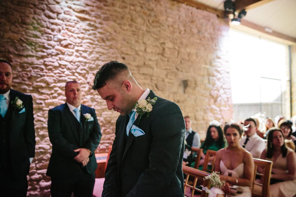 Groom waiting at the top of the aisle for bride
