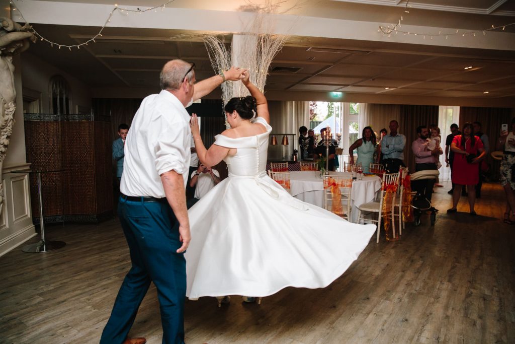 Bride dancing with her Dad, manor by the lake
