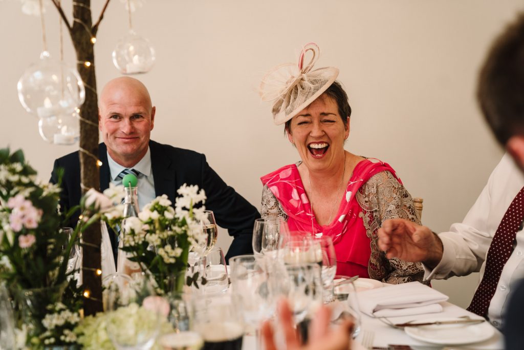 guest laughing during wedding speeches