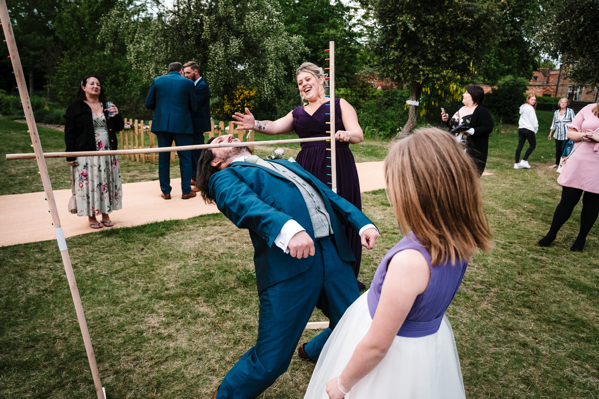 groom playing limbo at castle bromwich hall gardens