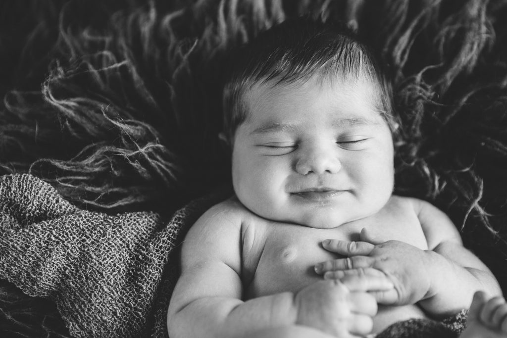 newborn baby smiling in his sleep