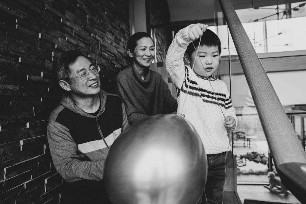 Grandparents and grandson playing with a balloon 
