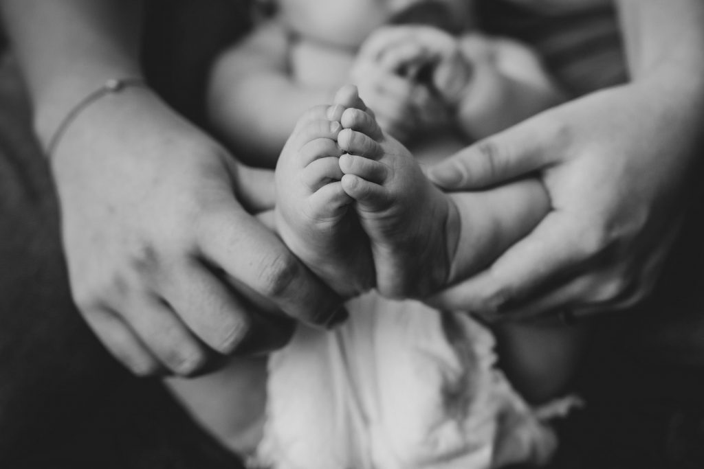 Mum holding her baby's feet. 