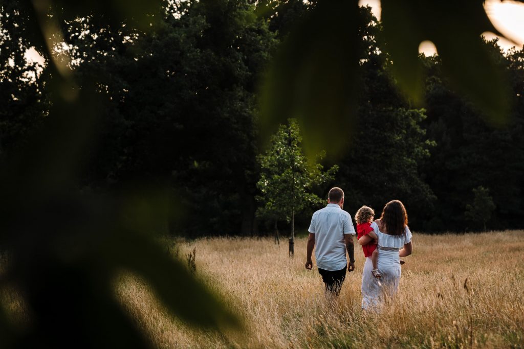 family walking though a field of long grass on a family shoot