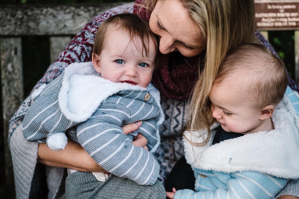 mum cuddling twins and holding them close during photoshoot