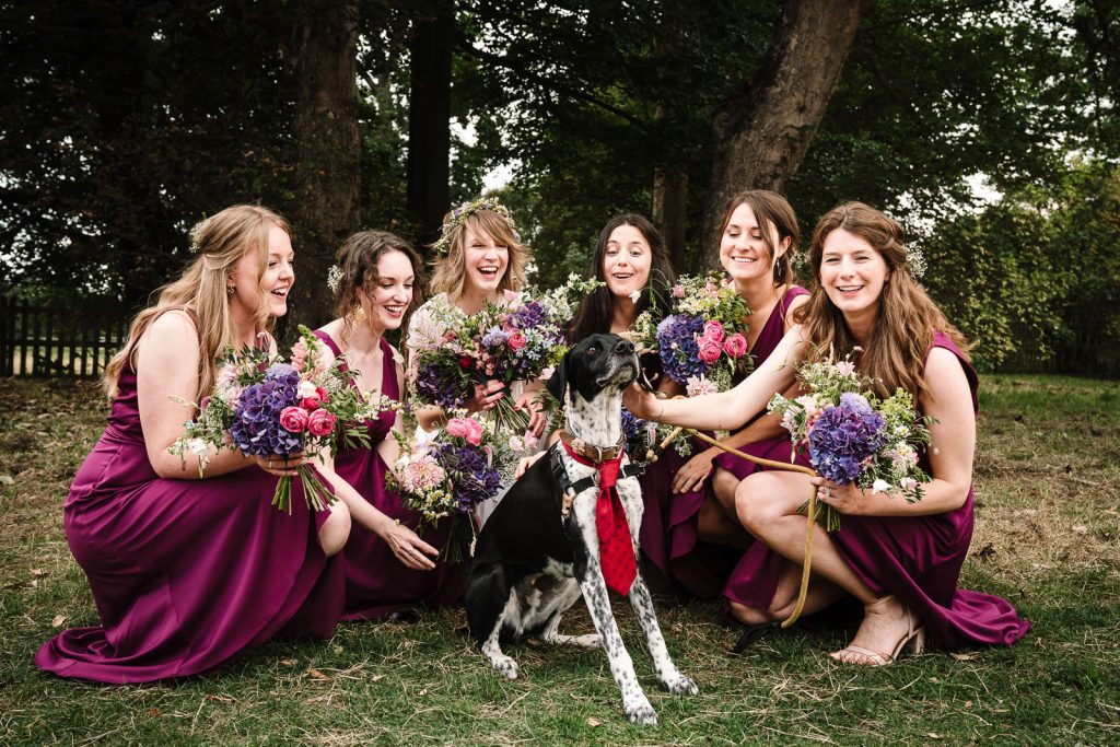 bridesmaids and dog posing for a photograph 