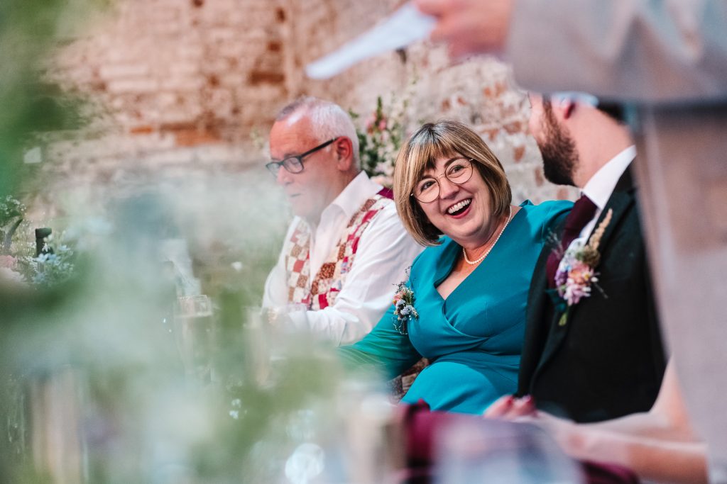 mother of the bride laughing at wedding speech 