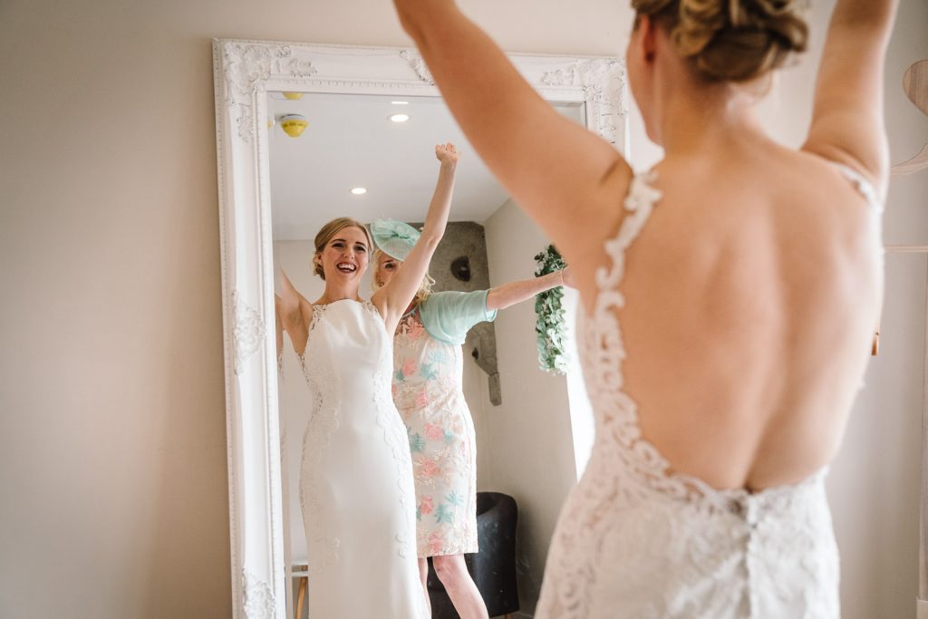 bride cheering,putting on her wedding dress before her wedding