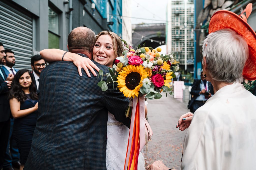 bride hugging her dad after wedding